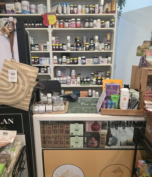 El mostrador de la tienda con cosmética natural y, detrás, estanterías de fitoterapia y suplementos.