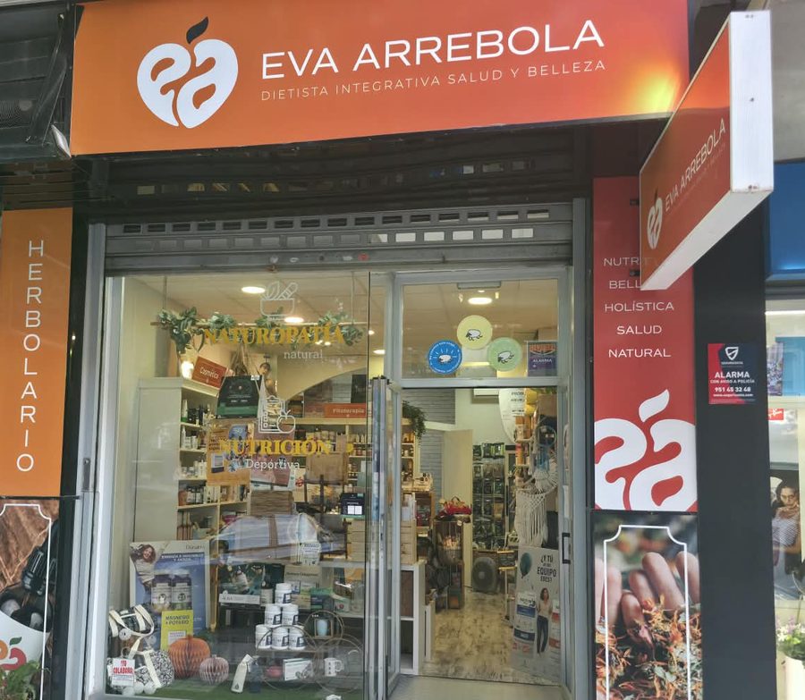Fachada de la tienda Eva Arrebola, con el rótulo naranja, el escaparate y la palabra Herbolario.